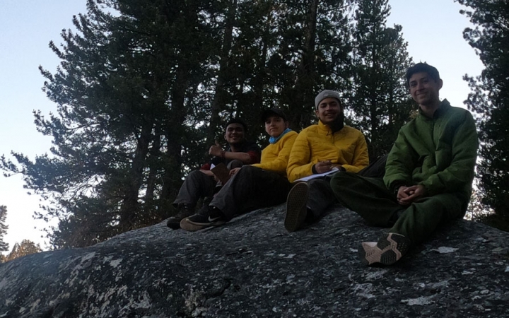 a group of students rest on a rock during an outward bound backpacking expedition for bipoc